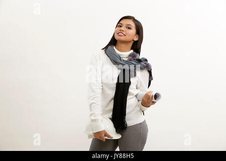 Junge weibliche Architekt Holding blauer Druck auf weißem Hintergrund Stockfoto