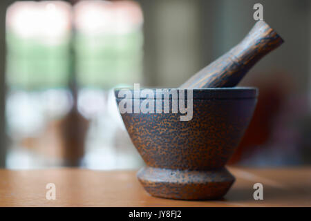 Holz Mörser und Stößel auf einer hölzernen Schreibtisch und Wohnzimmer Hintergrund Stockfoto