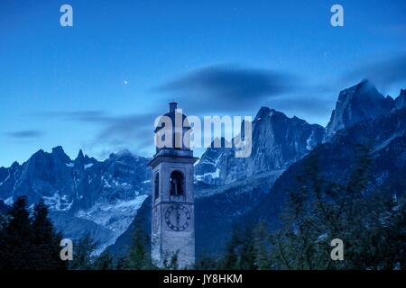 Dämmerung in Soglio, mit dem Kirchturm des Dorfes und auf der granitischen Gipfel des Pizzo Badile und Pizzo Cengalo. Val Bregaglia, Schweiz Stockfoto