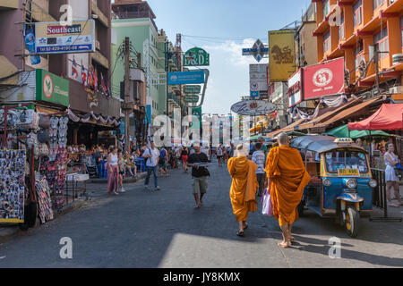 Zwei buddhistische Mönche unter der Menge von Ausländern, Essensstände und Leuchtreklamen in Khao San Road in Bangkok, Thailand Stockfoto
