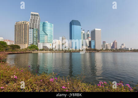 Benjakiti Park in Bangkok, Thailand Skyline mit See Ratchada, Bougainvilleas und Wolkenkratzer Stockfoto