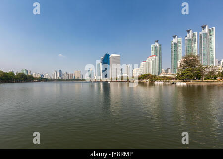 Benjakiti Park in Bangkok, Thailand Skyline mit See Ratchada, Bougainvilleas und Wolkenkratzer Stockfoto