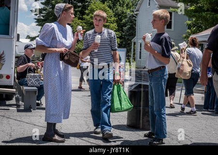 Lancaster, Vereinigte Staaten von Amerika - 27. Juni 2017. Eine Frau mit ihren zwei Söhnen auf der Root-Land Markt und Auktion. Die Mutter ist das Tragen der traditionellen Kleidung der Mennoniten, während ihre beiden Söhne tragen sind normale Kleidung. Stockfoto