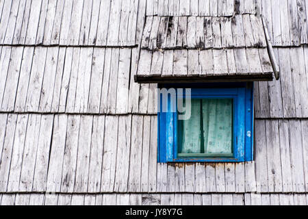 Alte Blaue Fenster auf hölzernen Schindeln Dach Haus Stockfoto
