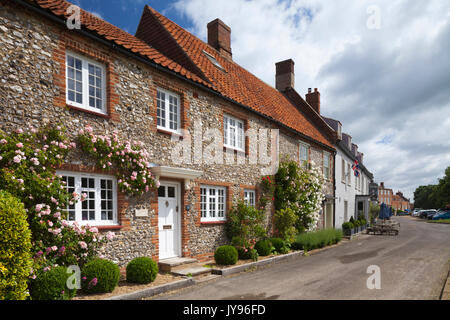 Traditionell gebauten Rose - überdachte Backstein und Feuerstein Cottages und hoste Pub in der malerischen Ortschaft Burnham Market in Norfolk, England. Stockfoto