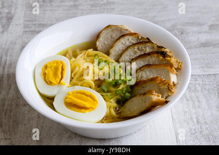 Japanische Ramen Suppe mit Hähnchen und gekochtem Ei in Weiß Schüssel Stockfoto