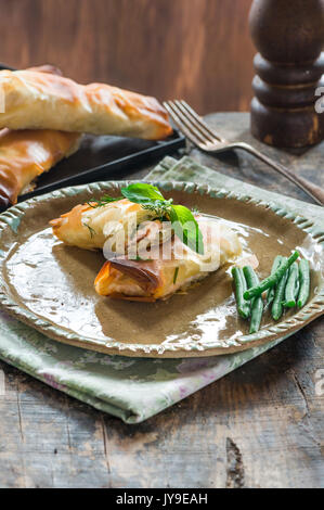 Lachs und Basilikum Butter filo Pakete mit grünen Bohnen Stockfoto