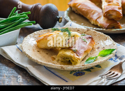 Lachs und Basilikum Butter filo Pakete mit grünen Bohnen Stockfoto