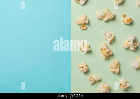 Das Popcorn in Pappbecher auf grünen und blauen Hintergrund. Stockfoto