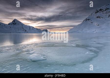 Die glatte Eis und abgehackt Splits sind von einer dunklen Himmel getrübt durch phantasievolle Glasuren verbessert. Weißer See. Berninapass. Schweiz Stockfoto