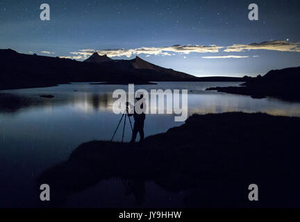 Fotograf bewundert Reflexion über rosset See bei Nacht. Nationalpark Gran Paradiso. Alpi graie Stockfoto