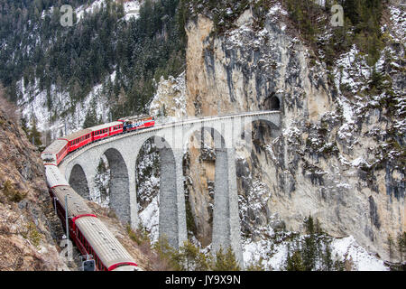 Bernina Express führt durch Landwasser Viadukt und verschneiten Wälder Filisur Kanton Graubünden-Schweiz-Europa Stockfoto