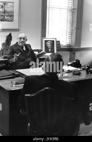 Milton Stover Eisenhower (links), Präsident der Johns Hopkins Universität, saß an seinem Schreibtisch und Sprechen zu einem Gast, Februar, 1962. Stockfoto