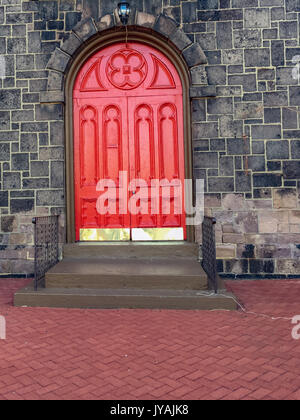 Rote bogenförmige Doppeltür mit golden Kick Platte Stockfoto