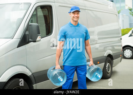 Lieferung Mann mit zwei große Flaschen Wasser stand vor der Lieferung Van Stockfoto