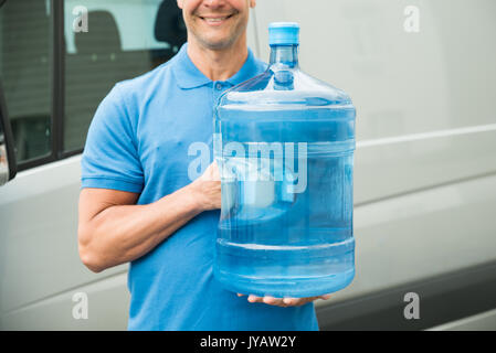 Nahaufnahme der Mann in der blauen Uniform, die große Flasche Wasser Stockfoto