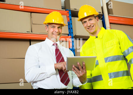 Portrait von Happy Lagerarbeiter und Manager in einem Lager Stockfoto