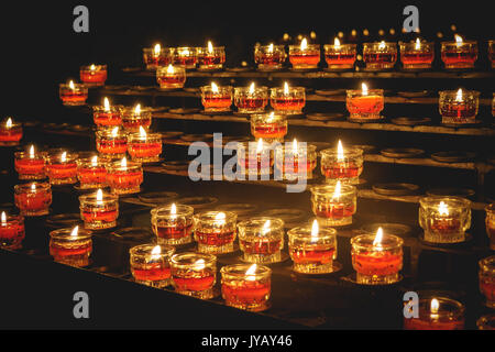 Reihen von Votiv Kerzen in einer katholischen Kirche. Querformat. Stockfoto