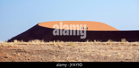 Touristen zu Fuß auf die Dünen vom Wind Deadvlei Sossusvlei Namib Naukluft National Park in Namibia Afrika geformt Stockfoto