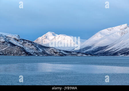 Blauer Himmel und schneebedeckten Gipfeln umgeben das kalte Meer Lyngen Alpen Tromsø Lappland Norwegen Europa Stockfoto