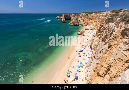 Touristen am Sandstrand Praia da Marinha von türkisblauem Meer Caramujeira Gemeinde Lagoa Algarve Portugal Europa umgeben Stockfoto