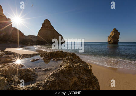 Erste Sonnenstrahlen auf den Klippen und türkisfarbenem Wasser am Praia da Marinha Caramujeira Lagoa Gemeinde Algarve Portugal Europa Stockfoto