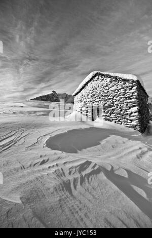 Schwarz-weiß Foto zeigt eine Kabine von olano Alp weiß getünchten durch einen Schneesturm. Rasura. Valgerola. Bergamasker Alpen. Valtellina. In der Lombardei. Italien. Eu Stockfoto