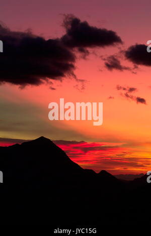 Die hellen Farben eines Sonnenuntergangs über den Monte Legnone, Bergamasker Alpen, Valtellina, Lombardei Italien Europa Stockfoto