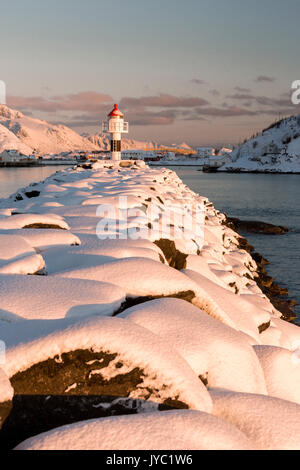 Der Leuchtturm von Schnee Frames die schneebedeckten Gipfel und das gefrorene Meer Reine Nordland Lofoten norwegen Europa umgeben Stockfoto