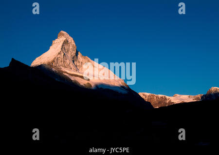 Die wunderschöne Pyramide der schneebedeckten Gipfel des Matterhorns bei Sonnenaufgang mit einer Kappe bedeckt, aus dem Tal von Zermatt im Kanton Wallis in der Schweiz E Stockfoto