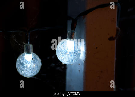 Makro Aufnahmen von Spinnweben auf bläuliche Kugel string Lichter gebaut Stockfoto