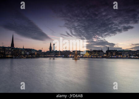 Die Farben und das Licht der Dämmerung auf der Binnenalster mit dem Weihnachtsbaum in seinem Wasser Hamburg Deutschland Europa ausgesetzt Stockfoto