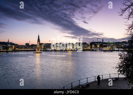 Die Farben und das Licht der Dämmerung auf der Binnenalster mit dem Weihnachtsbaum in seinem Wasser Hamburg Deutschland Europa ausgesetzt Stockfoto