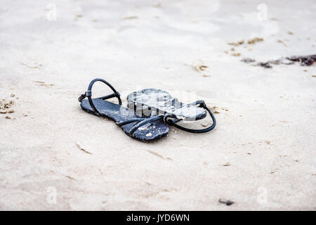 Schwarze Schuhe in den weißen Strand sand Stockfoto