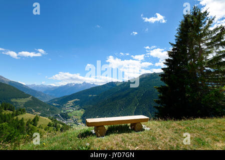 Sitzbank und eine geschwungene Landstraße in einer Berglandschaft Stockfoto