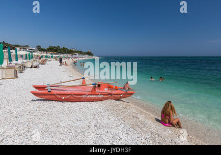 Touristen am Strand durch das türkisfarbene Meer Provinz Ancona Riviera del Conero Marche Italien Europa gerahmt Stockfoto