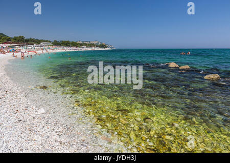 Touristen am Strand durch das türkisfarbene Meer Provinz Ancona Riviera del Conero Marche Italien Europa gerahmt Stockfoto