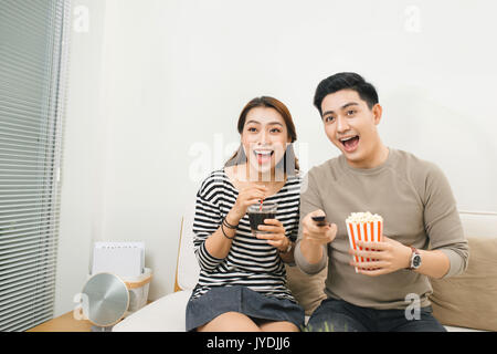 Entspannte junges Paar vor dem Fernseher in ihrem Wohnzimmer Stockfoto