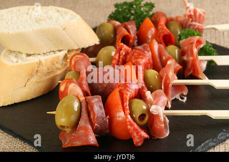 Tapas Auswahl an Fleisch mit Oliven und Tomaten auf Spieße Stockfoto