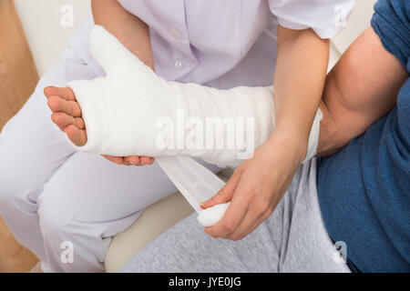 Nahaufnahme einer Pflegekraft Dressing Patienten Hand mit Verband Stockfoto