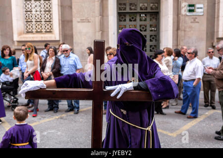 Büßer gestellt sein Kreuz während der Heiligen Woche Prozession Holding, Spanien Stockfoto