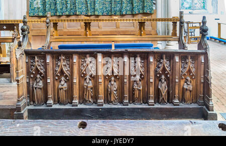 Mittelalterliche Chorgestühl mit geschnitzten Figuren von Heiligen und Apostel, Interieur der Kirche der Heiligen Dreifaltigkeit, Blythburgh, Suffolk, England Stockfoto