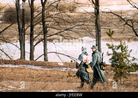 Rogachev, Belarus - Februar 25, 2017: Zwei nicht identifizierte Re-enactors gekleidet, wie Deutsche Wehrmacht Infanterie Soldaten im Zweiten Weltkrieg marschierten entlang Fores Stockfoto