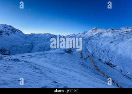 Blaues Licht der Dämmerung auf die verschneite Landschaft und die Serpentinen des Stilfser joch braulio Tal Veltlin lombardei Italien Europa Stockfoto