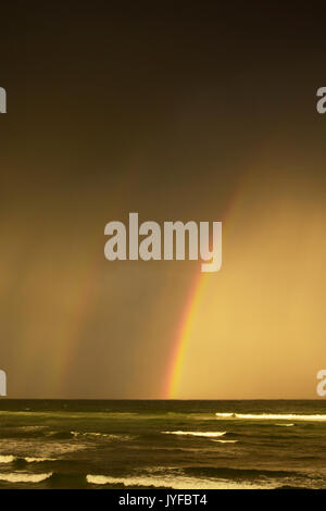 Regenbogen über dem Meer mit stürmischen Himmel, Seven Mile Beach, New South Wales, Australien Stockfoto