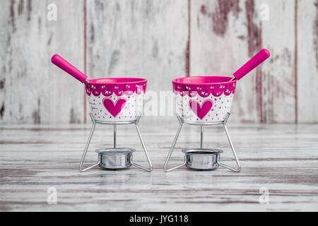 Dekorative Schokoladenfondue Schüssel und Stöcken auf weißem Holz Hintergrund Stockfoto