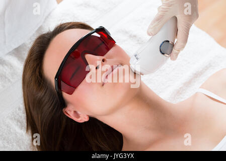 Junge Frauen, die Epilation Laser Behandlung im Gesicht im Schönheitscenter Stockfoto