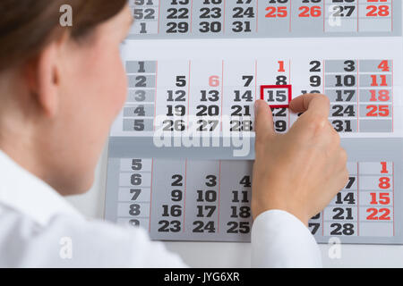 Nahaufnahme der Geschäftsmann, der Kennzeichnung von wichtigen Datum im Kalender Stockfoto