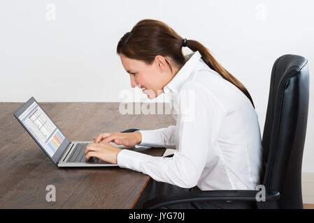 Junge glücklich Geschäftsfrau Arbeiten am Laptop im Büro Stockfoto