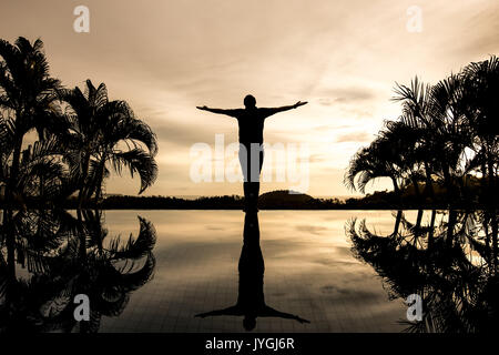 Silhouette-Mann mit offenen Armen allein stehend Stockfoto